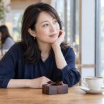 カフェで贈り物を前に気持ちを整理する女性