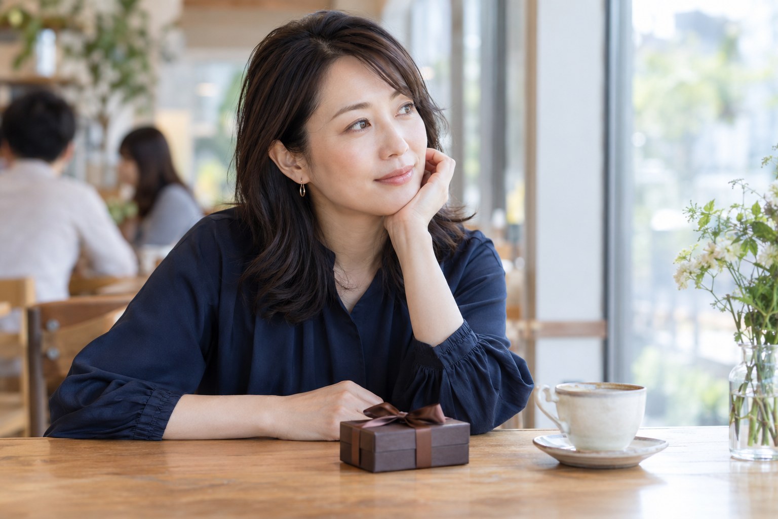 カフェで贈り物を前に気持ちを整理する女性