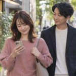 デートの帰りにスマートフォンを見る女性