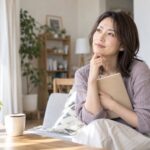 約束についてノートを手に考える女性