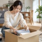 服を段ボール箱へ梱包する女性