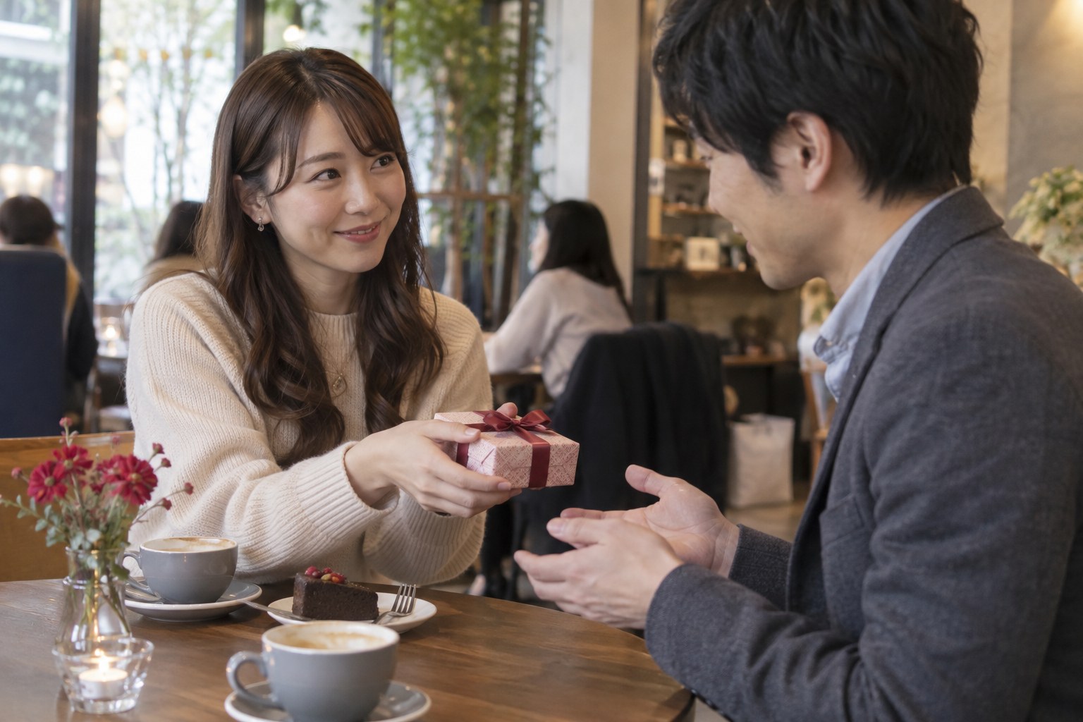 カフェで小さな贈り物を渡す女性